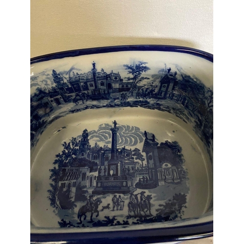 238 - AN OVAL BLUE AND WHITE FOOT BATH, with painted decoration to interior and exterior depicting country... 