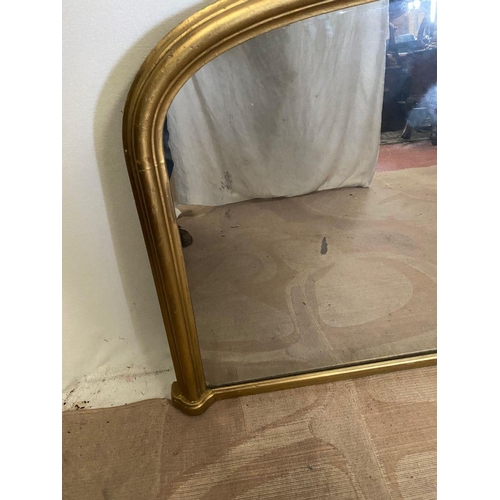 242 - A VICTORIAN GILT OVERMANTLE MIRROR, of arched form with fluted gilt frame. Dimensions: 136cm x 83cm ... 