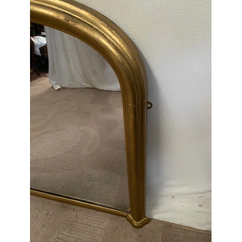 242 - A VICTORIAN GILT OVERMANTLE MIRROR, of arched form with fluted gilt frame. Dimensions: 136cm x 83cm ... 