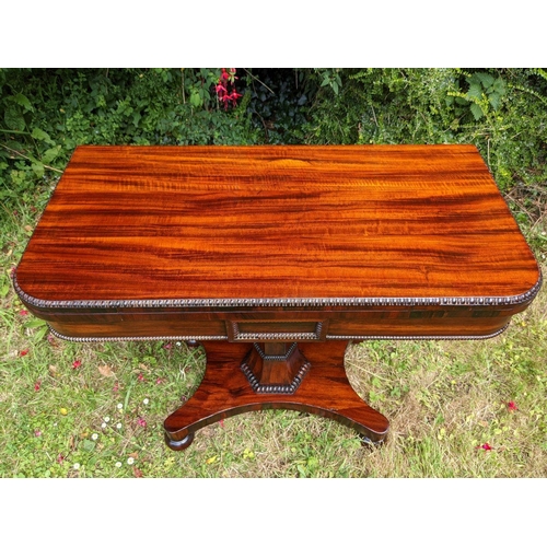 244 - A VERY FINE REGENCY ROSEWOOD FOLD OVER CARD TABLE, the rounded body decorated with gadrooned detail ... 