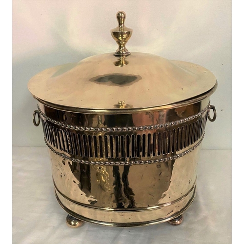 255 - AN OVAL SHAPED BRASS COAL/LOG BOX, with two handles, decorative finial to cover, pierced design surr... 