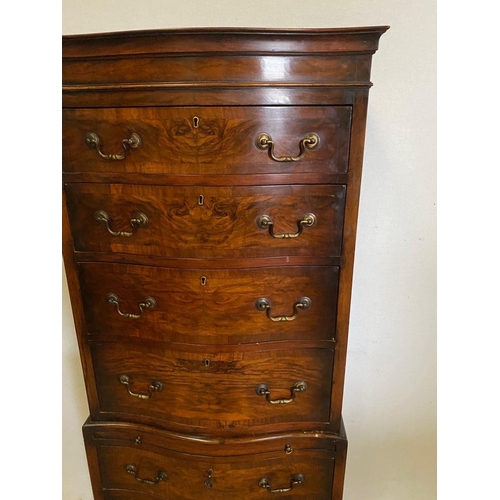 260 - A WALNUT SERPENTINE CHEST ON CHEST, with shaped cornice, four above three drawers with brass handles... 