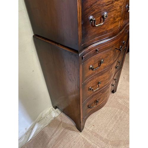 260 - A WALNUT SERPENTINE CHEST ON CHEST, with shaped cornice, four above three drawers with brass handles... 