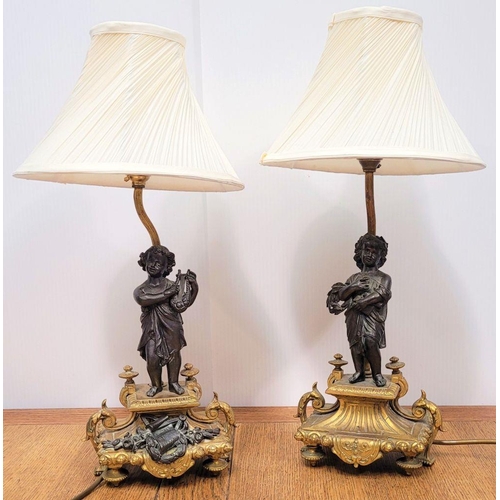 288 - A PAIR OF HEAVY PATINATED BRONZE & GILT CAST TABLE LAMPS, each with a small figure, one holding a mu... 