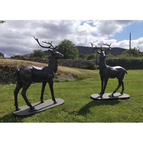 293 - A LARGE PAIR OF CAST METAL GARDEN ORNAMENTS IN THE FORM OF STAGS, each standing on a platform base. ... 