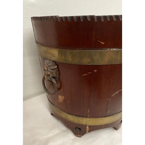 301 - A CIRCULAR MAHOGANY IRISH JARDINIERE, with carved top, double brass banding, lion head handles to si... 