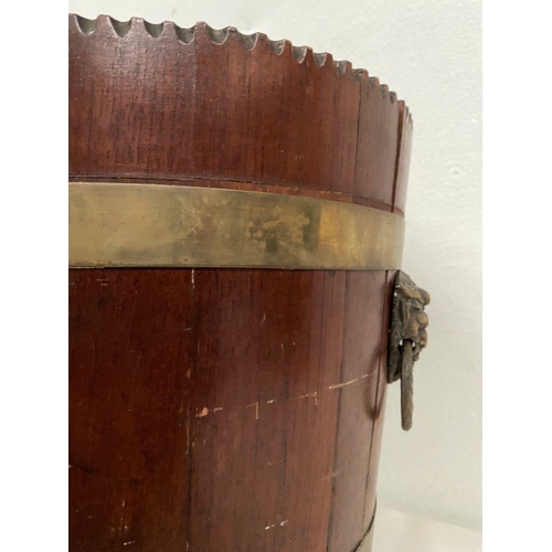 301 - A CIRCULAR MAHOGANY IRISH JARDINIERE, with carved top, double brass banding, lion head handles to si... 