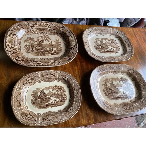 305 - A SET OF FOUR ANTIQUE IRISH WILLOW PLATTERS, brown design on white ground, marked to base. In good c... 