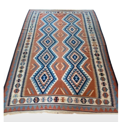 309 - A LARGE VIBRANT KELLIM RUG, wool, with geometric diamond pattern in blue, orange and navy on white g... 