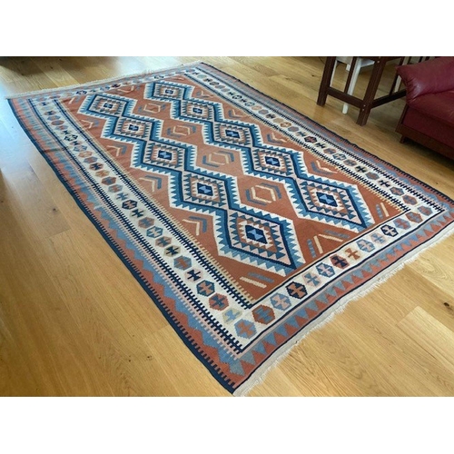 309 - A LARGE VIBRANT KELLIM RUG, wool, with geometric diamond pattern in blue, orange and navy on white g... 