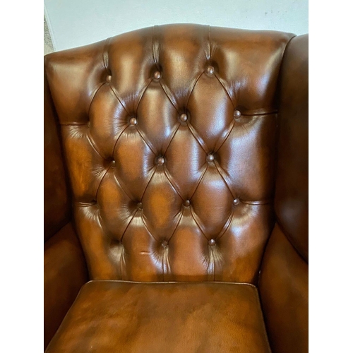 31 - A PAIR OF TAN LEATHER CHESTERFIELD WINGBACK ARMCHAIRS, stud upholstered with button back, scrolling ... 