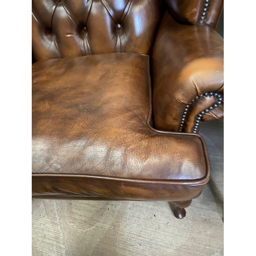 31 - A PAIR OF TAN LEATHER CHESTERFIELD WINGBACK ARMCHAIRS, stud upholstered with button back, scrolling ... 