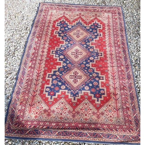 318 - A LARGE MID CENTURY MIDDLE EASTERN WOOL RUG, hand-made with triple diamond motif to centre surrounde... 