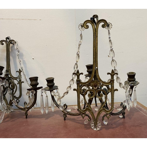 46 - A PAIR OF ANTIQUE BRONZE CRYSTAL WALL SCONCES, with three branches, shaped frame and hanging prisms.... 