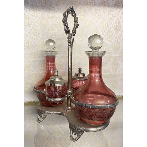 65 - AN ANTIQUE CRANBERRY GLASS CRUET SET, with two etched cranberry glass decanters with globe stoppers,... 