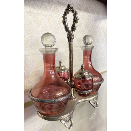 65 - AN ANTIQUE CRANBERRY GLASS CRUET SET, with two etched cranberry glass decanters with globe stoppers,... 