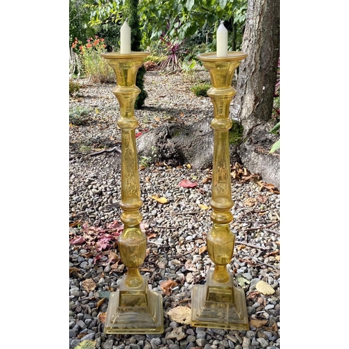 71 - A PAIR OF LARGE VINTAGE GLASS CANDLESTICKS, coloured glass, with turned supports on graduated square... 