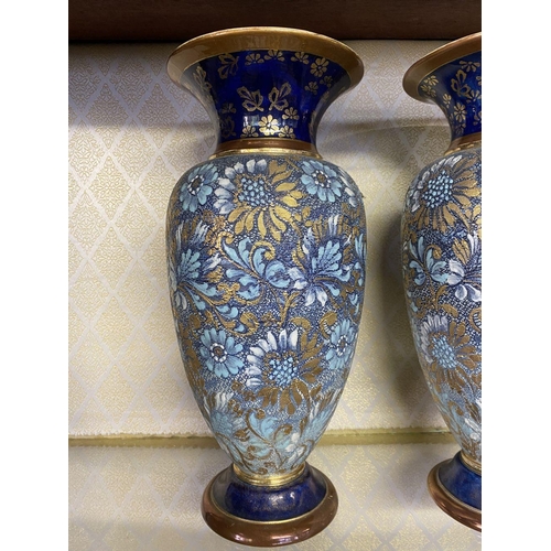 76 - A PAIR OF ROYAL DOULTON VASES, with painted blue neck and base, body decorated with white, gold and ... 