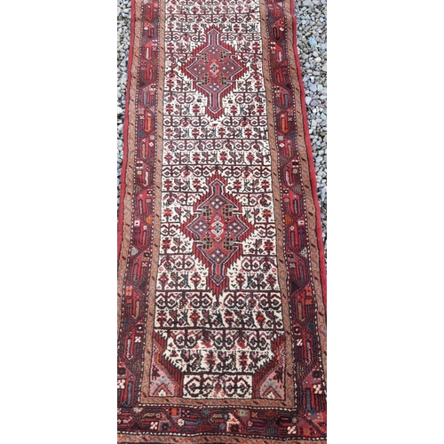 98 - A PERSIAN TAJABAD RUNNER RUG, featuring triple medallion design to centre, surrounded by floral moti... 