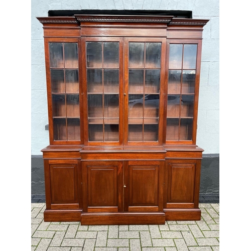 24 - A GOOD QUALITY IRISH MAHOGANY BREAK-FRONT LIBRARY BOOKCASE, to the top is a stepped cornice with den... 