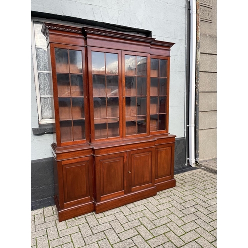 24 - A GOOD QUALITY IRISH MAHOGANY BREAK-FRONT LIBRARY BOOKCASE, to the top is a stepped cornice with den... 