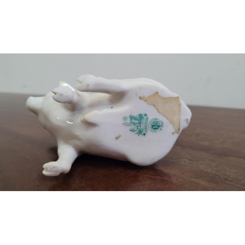 26 - A DELICATE IRISH BELLEEK PIG FIGURINE, with yellow lustre highlights, the seated pig is in excellent... 