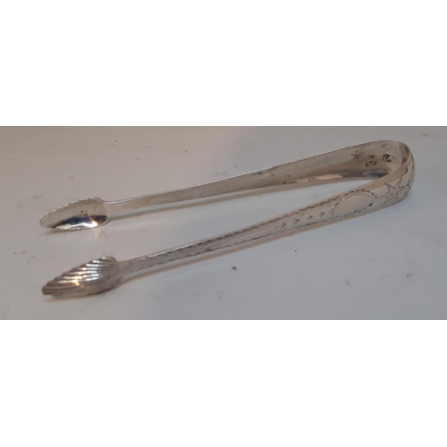 27 - AN GEORGIAN IRISH SILVER SUGAR TONGS, decorated with bright cut design to the stems & shell design t... 