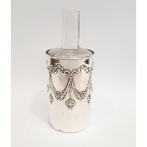 56 - AN EARLY 20TH CENTURY SILVER BOTTLE COVER with antique glass bottle within. The silver collar is dec... 