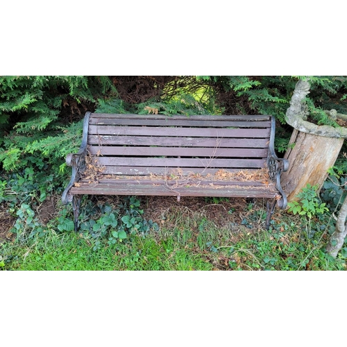 184 - A CAST IRON FRAMED GARDEN SEAT, on each side are cast iron frames with lion head & run design surrou... 
