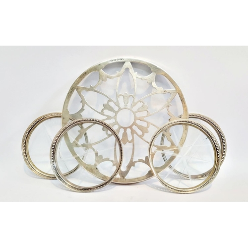 246 - A SILVER GLASS BOTTOMED TRIVET, with a set of four sterling rimmed glass bottomed coasters, the triv... 