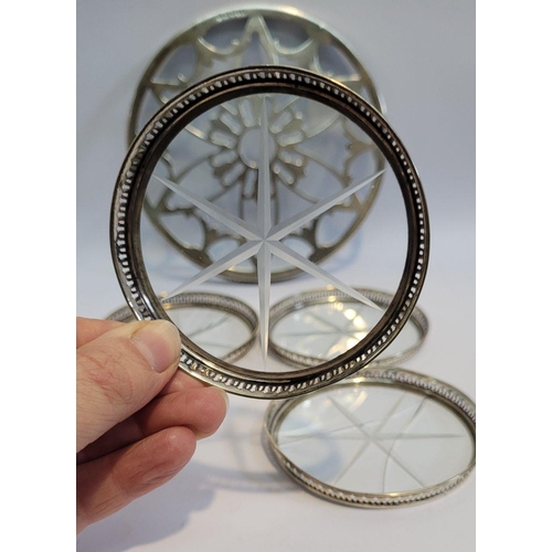 246 - A SILVER GLASS BOTTOMED TRIVET, with a set of four sterling rimmed glass bottomed coasters, the triv... 