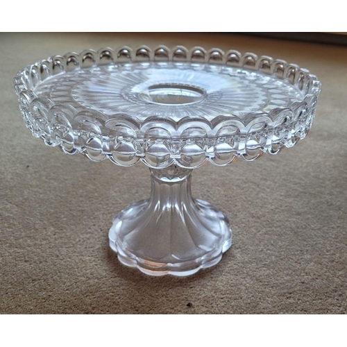 76 - A GOOD QUALITY VINTAGE GLASS CAKE STAND, with scalloped raised gallery edge to the top raised on a r... 