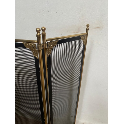 105 - A BRASS FRAMED THREE PANEL FOLDING FIRE SCREEN, with black mesh to the front and sides a pierced det... 