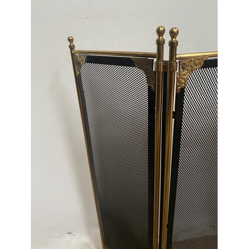 105 - A BRASS FRAMED THREE PANEL FOLDING FIRE SCREEN, with black mesh to the front and sides a pierced det... 