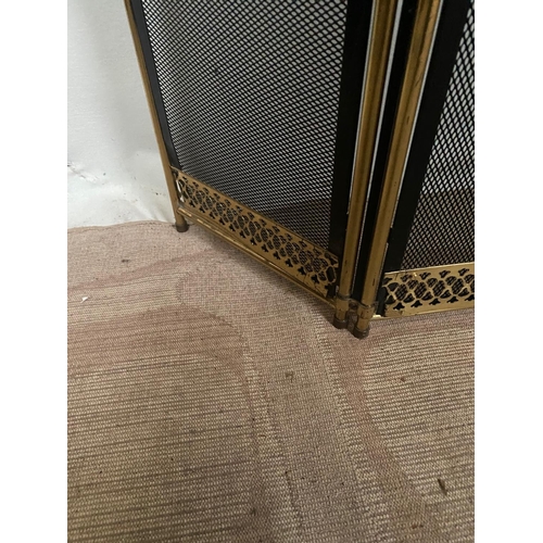 105 - A BRASS FRAMED THREE PANEL FOLDING FIRE SCREEN, with black mesh to the front and sides a pierced det... 