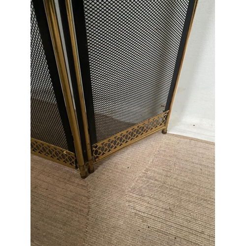 105 - A BRASS FRAMED THREE PANEL FOLDING FIRE SCREEN, with black mesh to the front and sides a pierced det... 