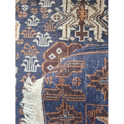 106 - AN AFGHAN BELOUCH FLOOR RUG, with overall ground colour blue; to the outside border are floral shape... 