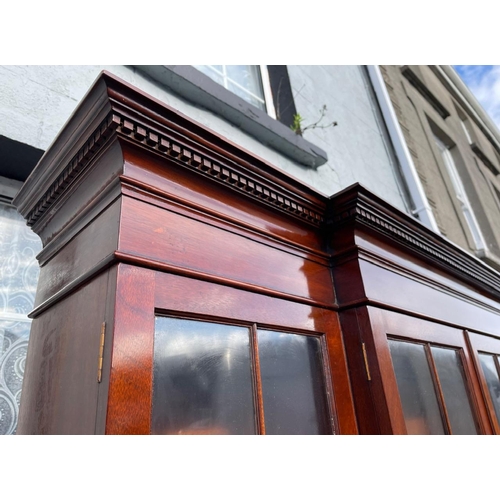 115 - A VERY GOOD QUALITY MAHOGANY LIBRARY BREAKFRONT GLAZED BOOKCASE, with stepped pediment having dentil... 