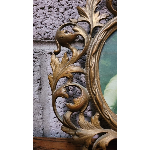 125 - A PAIR OF ANTIQUE GILT CAST METAL PICTURE FRAMES, each with scrolling foliage design, the rim of the... 