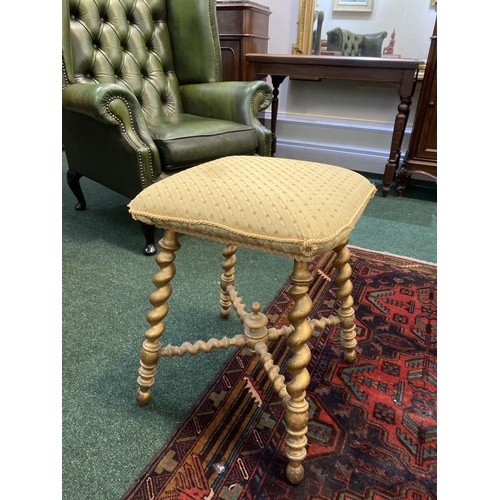 167 - A CHARMING 19TH CENTURY GILTWOOD BOBBIN STOOL, with cushioned upholstered seat, atop legs conjoined ... 