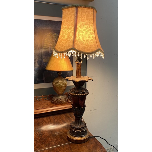 182 - A DECORATIVE AMBER GLASS GILT TABLE LAMP, with shaped support atop circular platform base and fringe... 