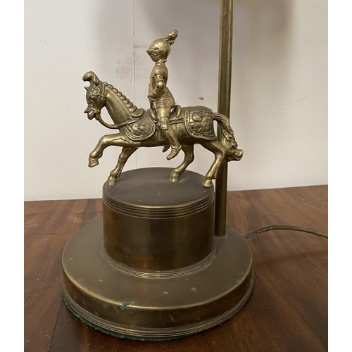 183 - A VINTAGE BRASS TABLE LAMP, with horse and solider atop circular platform base, complete with fringe... 