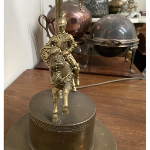 183 - A VINTAGE BRASS TABLE LAMP, with horse and solider atop circular platform base, complete with fringe... 