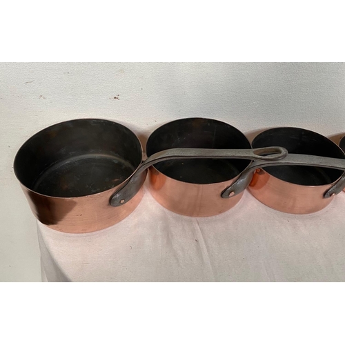 189 - A GOOD QUALITY SET OF SIX COPPER SAUCEPANS, each with a heavy cast iron handle with lopped tip to ai... 