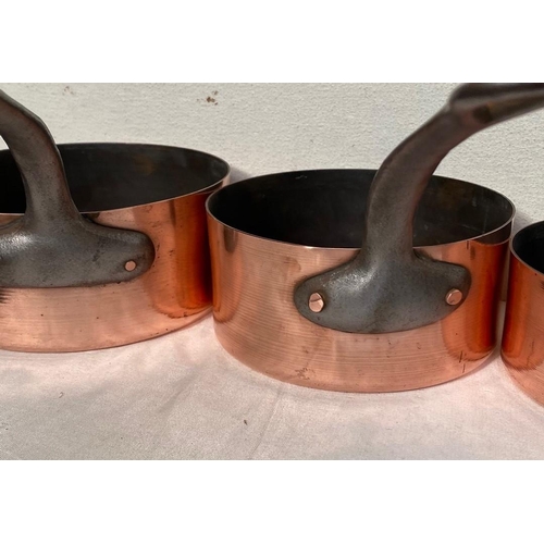 189 - A GOOD QUALITY SET OF SIX COPPER SAUCEPANS, each with a heavy cast iron handle with lopped tip to ai... 