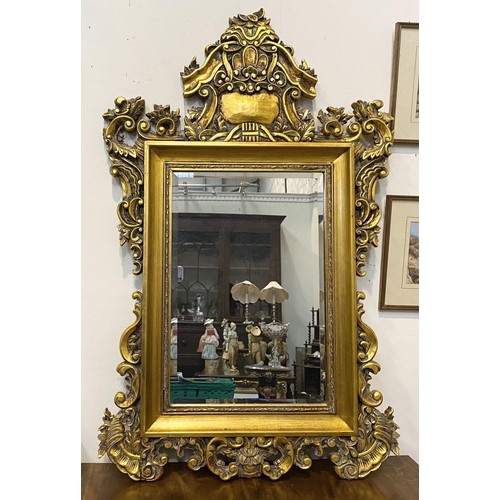 203 - A DECORATIVE VINTAGE OVERMANTLE MIRROR, rectangular form bevelled glass within ornate gilt carved fr... 