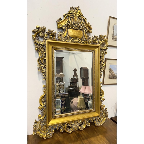 203 - A DECORATIVE VINTAGE OVERMANTLE MIRROR, rectangular form bevelled glass within ornate gilt carved fr... 