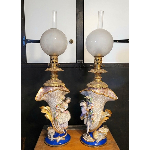 208 - AN IMPRESSIVE PAIR OF FRENCH PORCELAIN & BRASS OIL LAMPS, each with a detailed porcelain base, one w... 