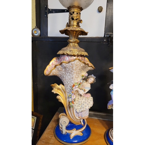 208 - AN IMPRESSIVE PAIR OF FRENCH PORCELAIN & BRASS OIL LAMPS, each with a detailed porcelain base, one w... 