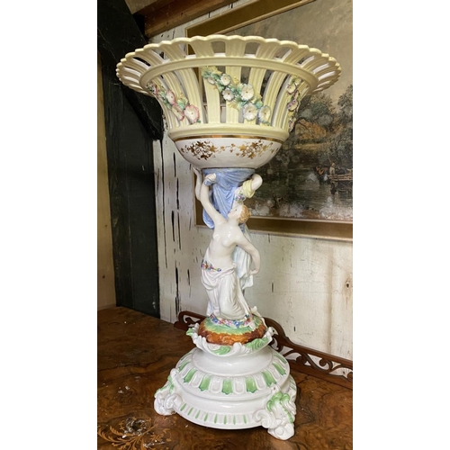 231 - A LARGE PORCELAIN COMPOTE CENTREPIECE, with flower encrusted basket, female figures to column standi... 